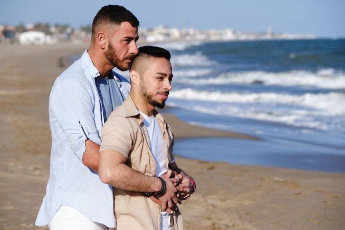 Male couple hugging on seaside