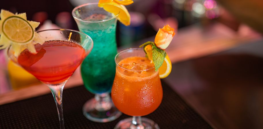 Wide shot of three tropical cocktails with garnishes