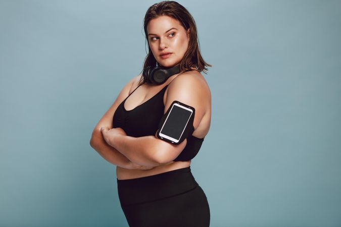 Plus size female model in sportswear with her arms crossed and looking away