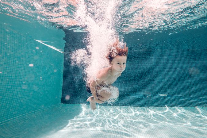 Little boy plunging in pool water