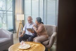Asian mature couple watching or video call with family on tablet