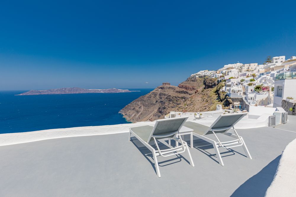 Two lounge chairs looking over Santorini