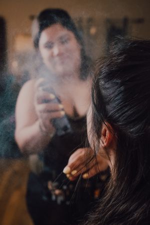 makeup artist using fixing spray for clients makeup