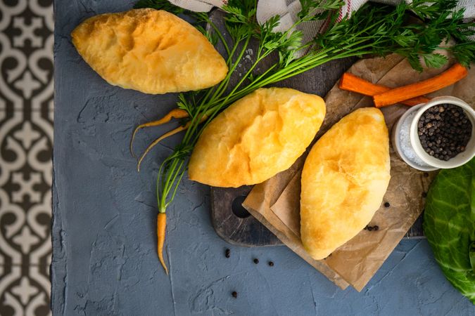 Traditional savory pies with cabbage and carrot on kitchen counter