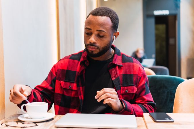 Black man with cup of coffee in cafe