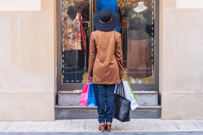 Charming woman in classy outfit shopping for dress