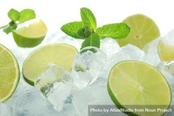 Pile of ice with lime halves and mint 561zV0