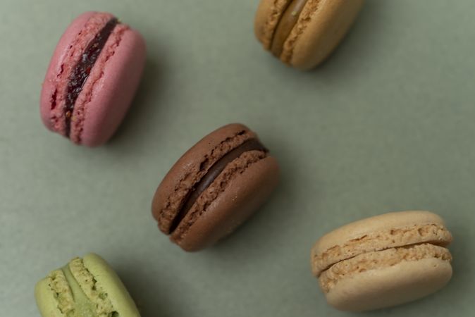 Delicious macaroons over a green background