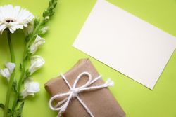 Top view of flowers with blank message card and gift