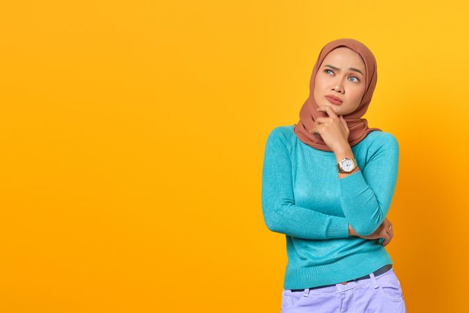 Contemplative Muslim woman thinking with hand on chin
