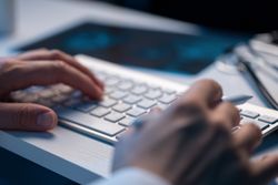 Doctor Typing on Keyboard in Office
