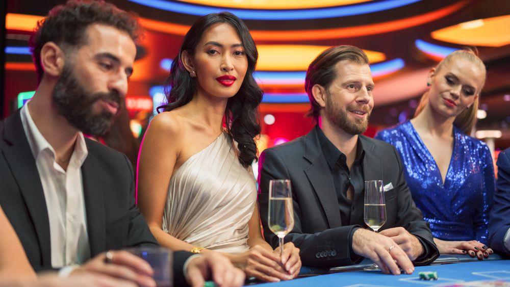 Portrait of a Glamorous Asian Woman Sitting at a Blackjack Table with Friends in a Modern Casino.