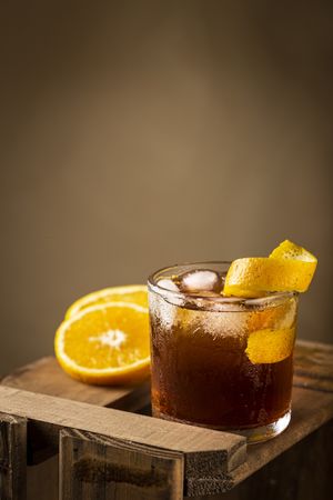 Negroni cocktail with orange, on wooden background.