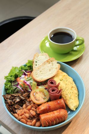 English Breakfast with Beans, Bacon, Egg Omelette, Salad, Bread,  and Sausages.