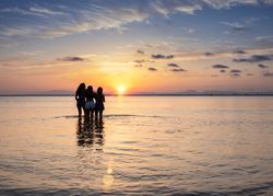 Women embracing on sunset at sea