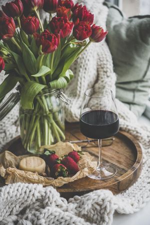 Wine and snacks with flowers and glasses on tray