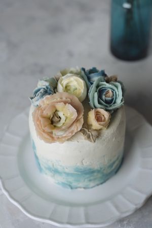 Buttercream flowers cake, blue and pastel peach colors