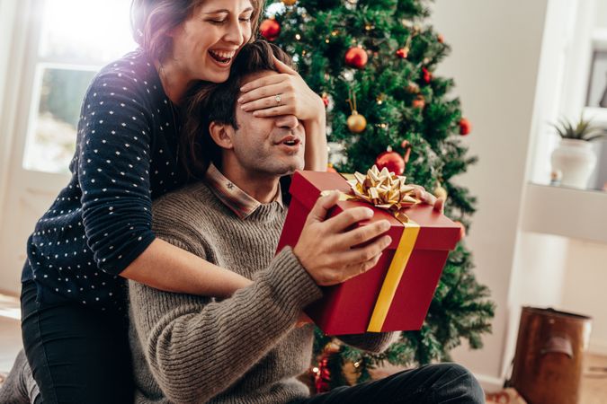 Young couple exchanging Christmas gifts