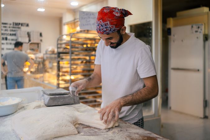 Arabic baker cutting dough with scapula