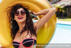 Portrait of woman in bikini posing with inflatable ring near swimming pool 5nLRDb