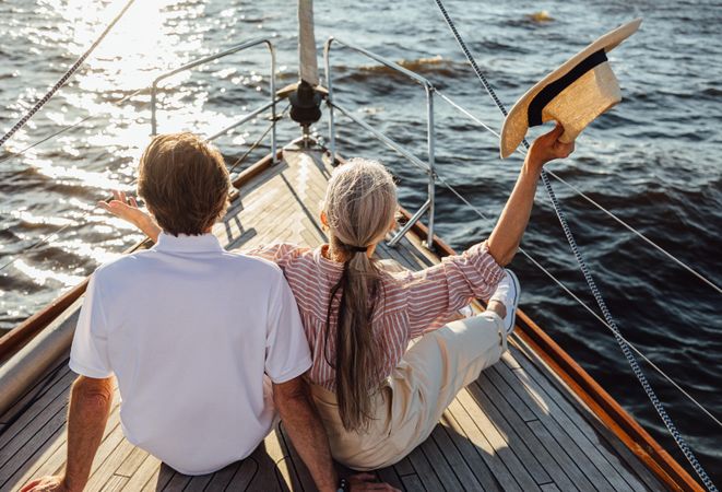 Back view of relaxed mature couple sitting on yacht