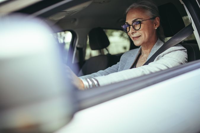 Mature businesswoman concentrating on road while driving a car