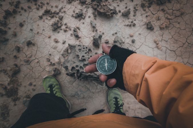 Compass in hand on dry desert area