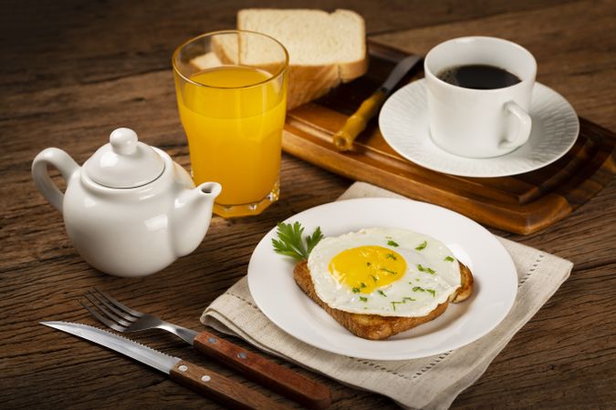 Breakfast with juice, coffee and toast with fried egg.