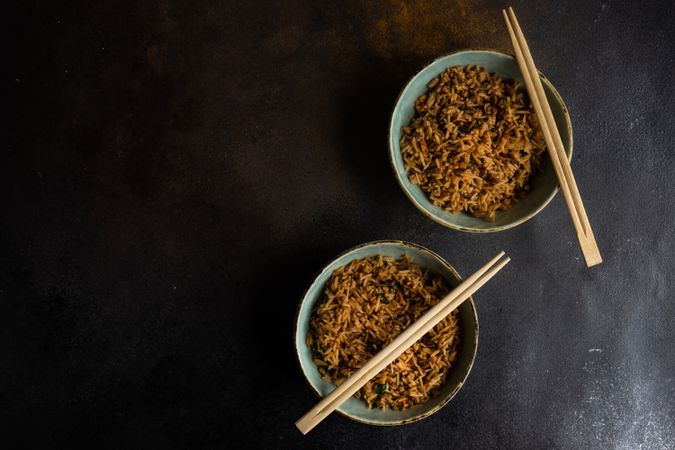 Two bowls of rice with chopsticks