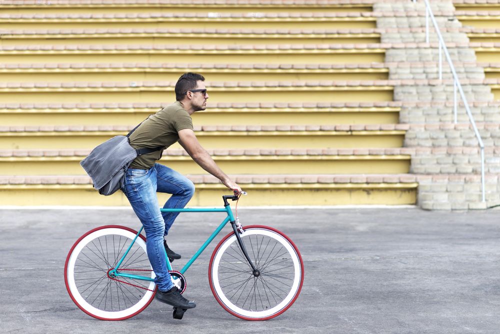 Male on bike with yellow outdoor seating in background