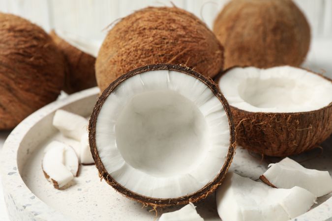 Tray with coconut on wooden background, close up. Tropical fruit