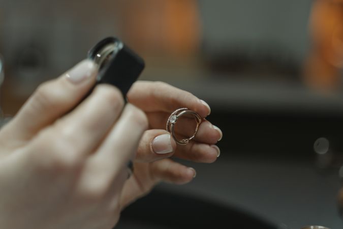 Cropped image of jeweler holding a magnifier to inspect a gold ring