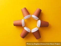 Disposable coffee cups on yellow background in circle shape 41yNl4