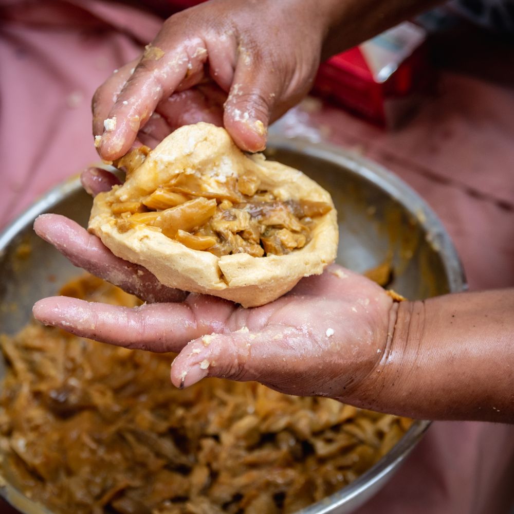 Person holding a bread with cheese