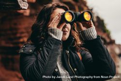 Woman traveler looking through binoculars 43BXO5