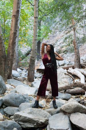 Young woman standing on boulders in the woods