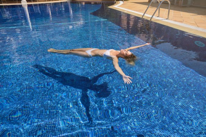 Female chilling while floating in pool water