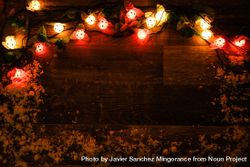 String of Christmas lights on dark wooden board 0LzYR4