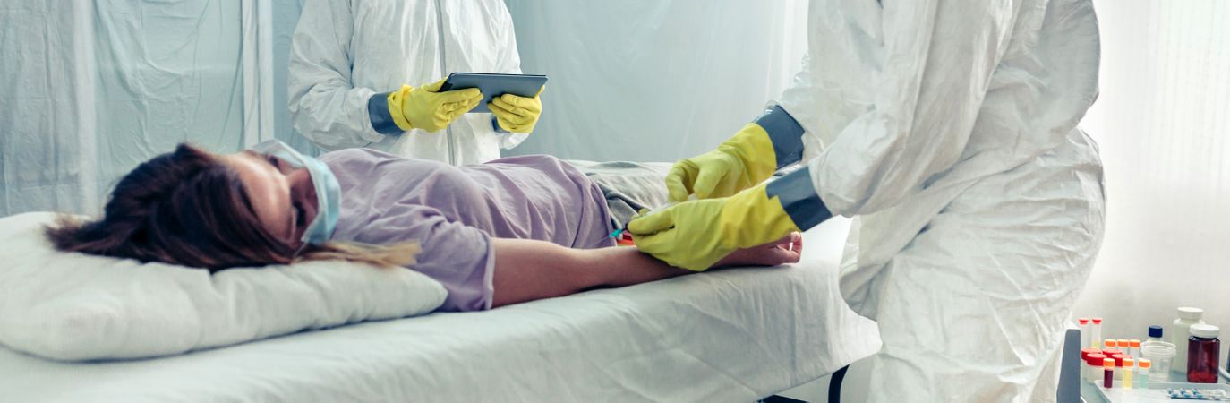 Doctors taking blood sample from patient lying on a gurney