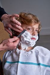 Boy shaving in a barbershop