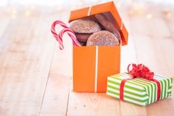 Gift with gingerbread and candy canes on wooden table