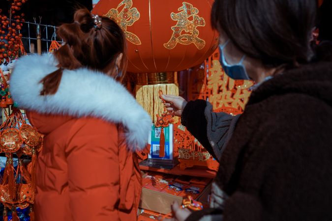 Back view of women looking at Chinese decoration