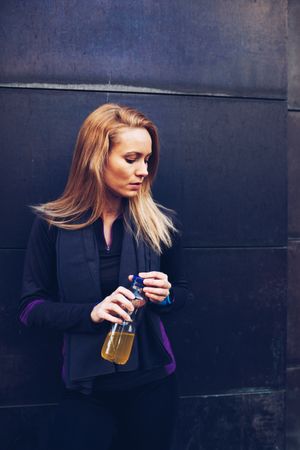 Woman drinking isotonic drink while resting