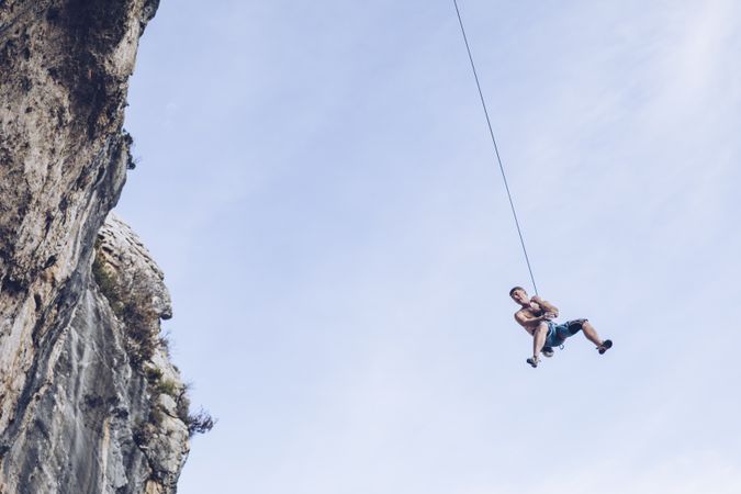 Anonymous climber handing on cliff