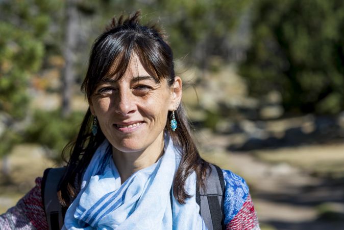 Female hiker smiling and standing in the woods