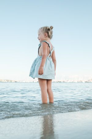 Little girl standing in sea at beach