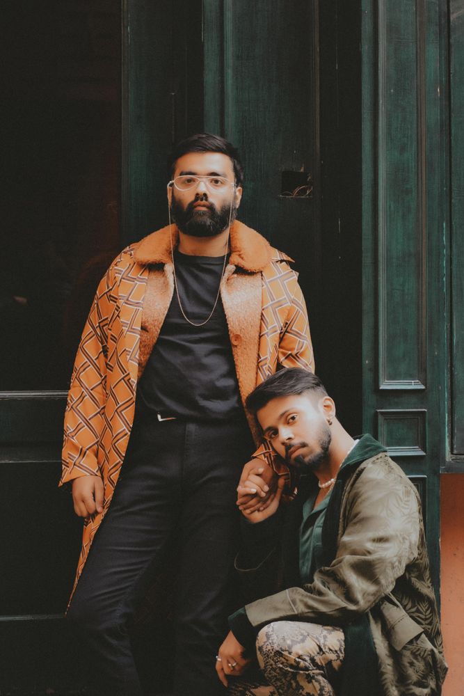 Two men holding hands and posing