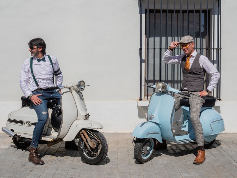 Trendy men sitting on vintage scooters