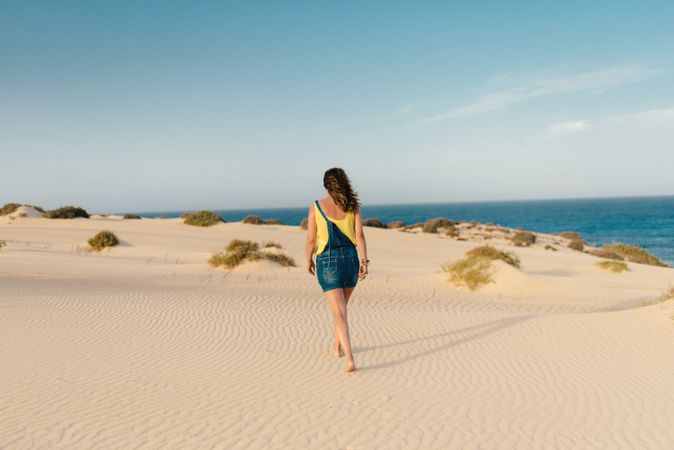 Active woman walking in dry desert barefoot