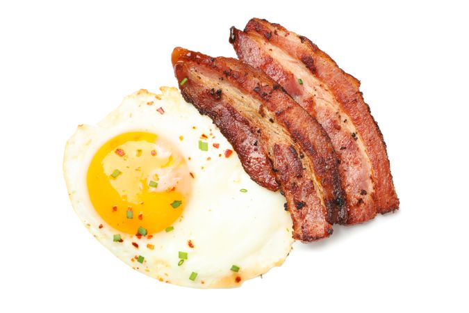 Top view of fried eggs and bacon rashers